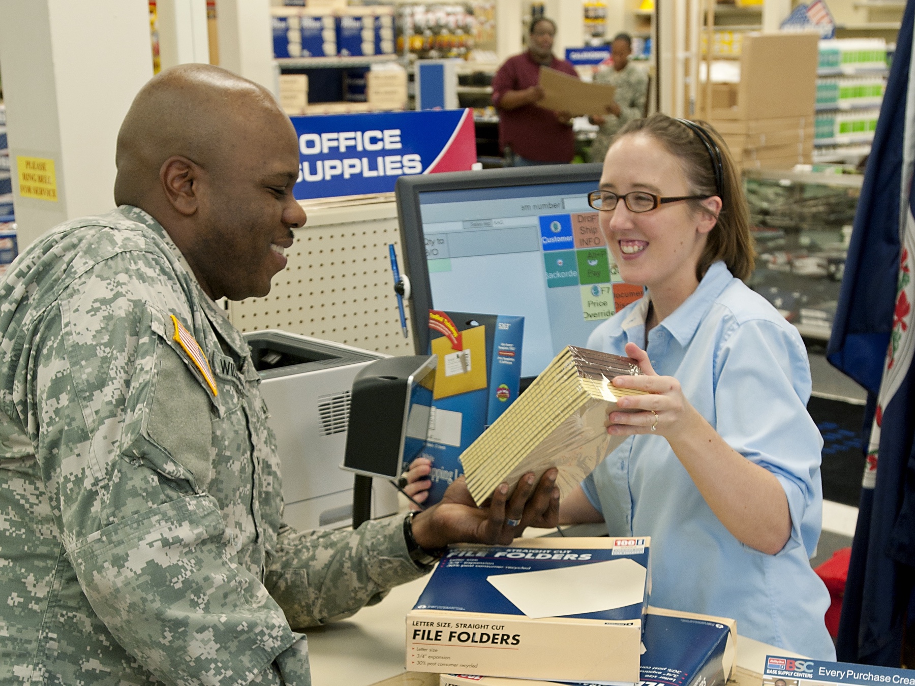 A solider checking out at a register with VIB employee